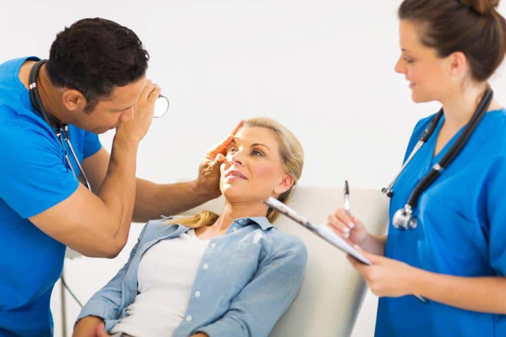 friendly ophthalmologist examining woman's eye