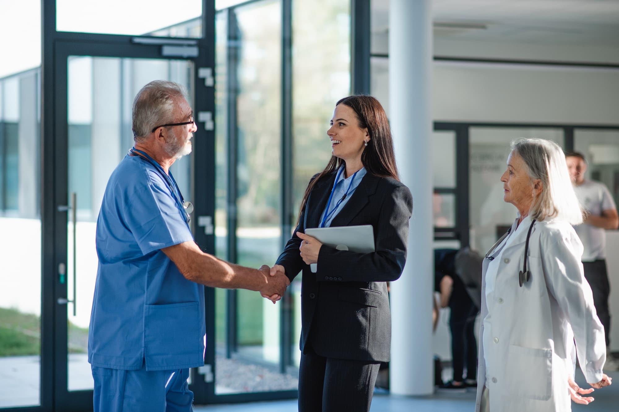 Young business woman shaking hand with doctor.