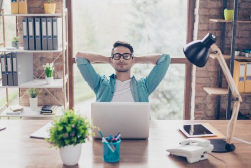 man sitting in front of laptop with his eyes closed
